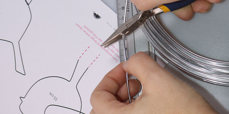 Ein entsprechend langes Stück Draht abschneiden. Vogel aus Aluminiumdraht biegen