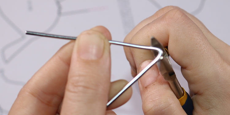 Für Kanten Draht mit der Zange zusammendrücken. Vogel aus Aluminiumdraht biegen