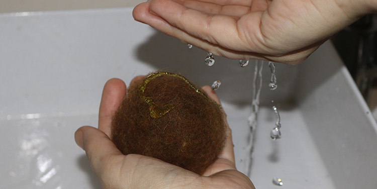 Wasser auf die Filzkugel tropfen Filzkugel mit Wasser und Seife besprengen