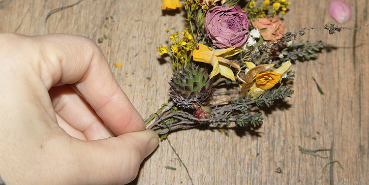 Sträußchen schuppenartig um den Kranz binden. Dabei Draht immer von außen nach innen um den Kranz führen und Blumen mitbinden. Frühlingskranz