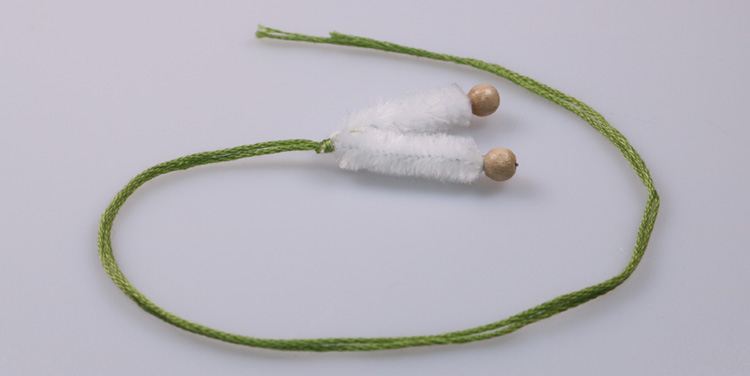 Ein Stück grünes Garn halbieren und an die Beine anknoten. Schneeglöckchen Beine