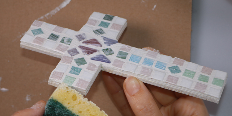 Mosaikkreuz mit dem Schwamm säubern