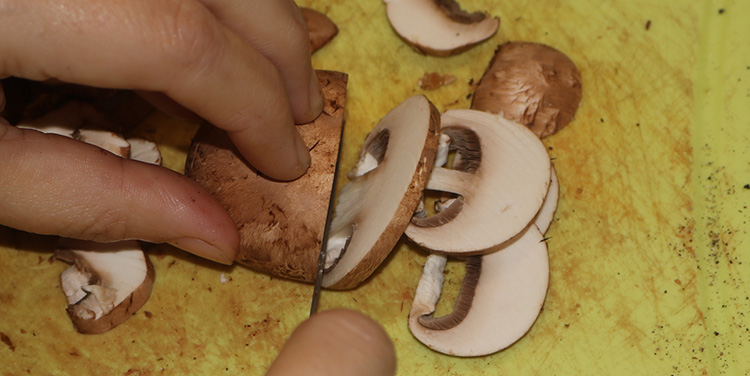 Gewaschene, abgetropfte Champignons blättrig schneiden. Boeuf Stroganoff Fleisch Champignon