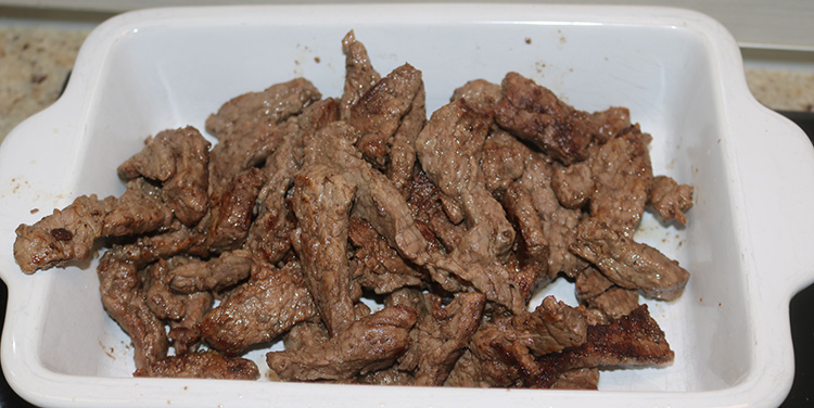 Das Fleisch nun aus der Pfanne nehmen und in einem geeigneten Behälter beiseite stellen. Boeuf Stroganoff Fleisch aus der Pfanne nehmen