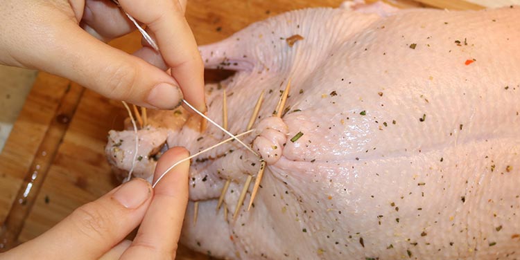 Wir verschließen die Ente mit Zahnstochern und Küchengarn Ente verschließen