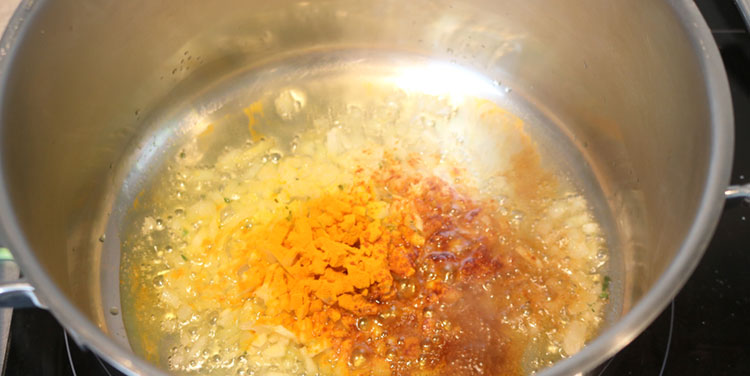 Zwiebel und Knoblauch zusammen mit Kurkuma und Paprikapulver anrösten. Zwiebel für Tomatensauce anroesten