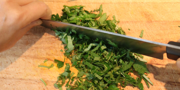 Kräuter fein hacken. Kräuter für Tomatensauce schneiden